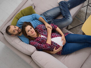 Image showing pregnant couple relaxing on sofa