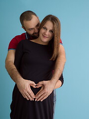 Image showing pregnant couple  isolated over blue background