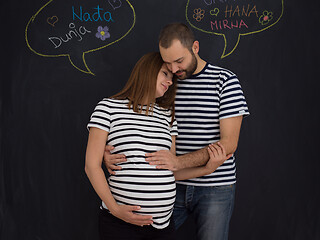 Image showing pregnant couple posing against black chalk drawing board