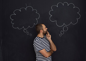 Image showing young future father thinking in front of black chalkboard