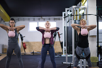 Image showing athletes doing exercises with kettlebells