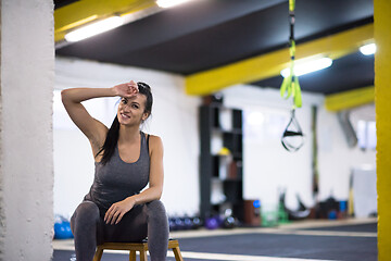 Image showing young athlete woman sitting and relaxing