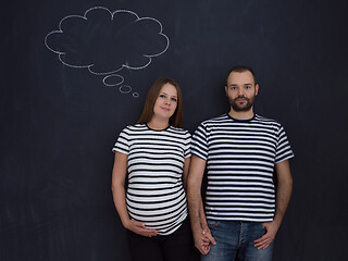 Image showing pregnant couple posing against black chalk drawing board