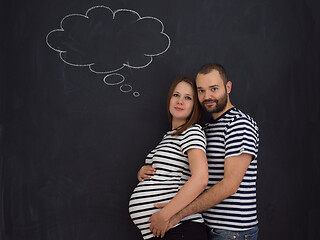 Image showing pregnant couple posing against black chalk drawing board