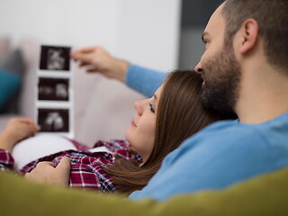 Image showing pregnant couple looking baby\'s ultrasound