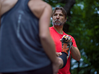 Image showing runners team warming up and stretching before morning training