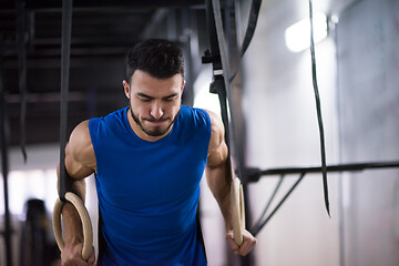 Image showing man working out pull ups with gymnastic rings