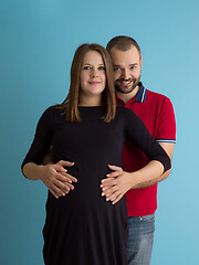 Image showing pregnant couple  isolated over blue background