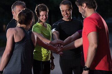 Image showing runners giving high five to each other