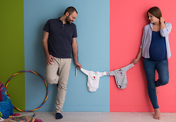 Image showing young couple holding baby bodysuits