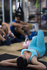 Image showing young athlete woman lying on the floor and relaxing