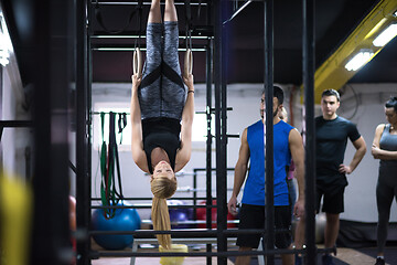 Image showing woman working out with personal trainer on gymnastic rings