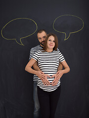 Image showing pregnant couple posing against black chalk drawing board