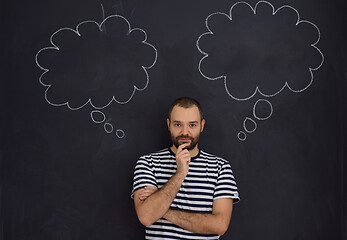 Image showing young future father thinking in front of black chalkboard