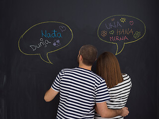 Image showing pregnant couple writing on a black chalkboard