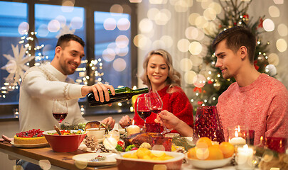 Image showing happy friends drinking red wine at christmas party