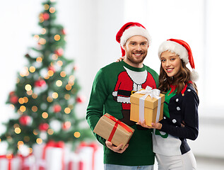 Image showing happy couple in sweaters with christmas gifts