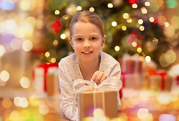 Image showing smiling girl with christmas gift at home