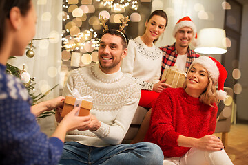 Image showing friends celebrating christmas and giving presents