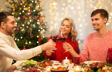 Image showing happy friends drinking red wine at christmas party