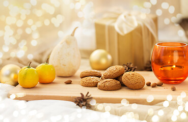 Image showing cookies, lemon, candle and christmas gift at home