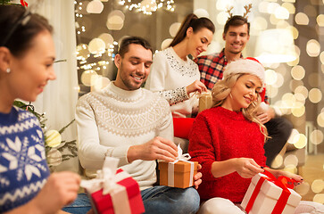 Image showing friends celebrating christmas and opening presents