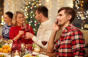 Image showing man calling on smartphone at christmas dinner