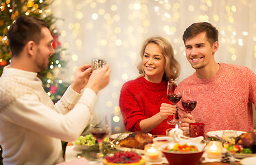 Image showing happy friends photographing at christmas dinner