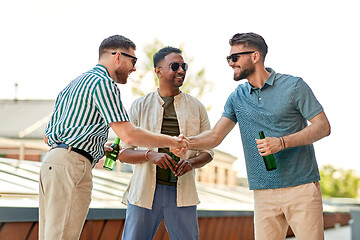 Image showing happy male friends drinking beer at rooftop party