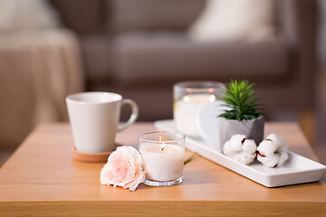 Image showing burning candle and flower bunch on wooden table