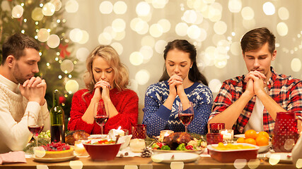Image showing friends praying before christmas dinner at home