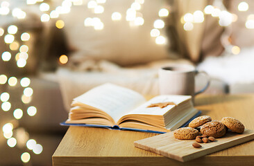 Image showing oat cookies, almonds and book on table at home