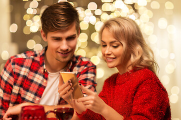 Image showing couple with smartphone at home christmas dinner