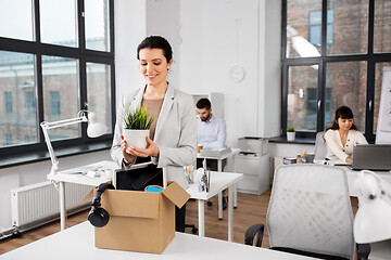 Image showing happy businesswoman with personal stuff at office