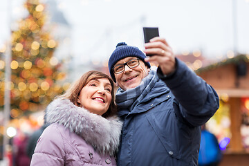 Image showing senior couple taking selfie at christmas market