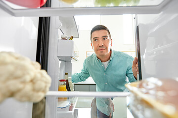 Image showing man looking for food in fridge at kitchen
