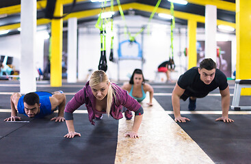 Image showing young healthy people doing pushups