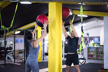 Image showing young athletes couple working out with medical ball