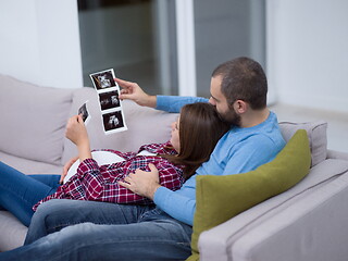 Image showing pregnant couple looking baby\'s ultrasound