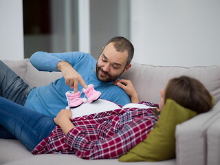 Image showing young pregnant couple relaxing on sofa