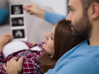 Image showing pregnant couple looking baby\'s ultrasound