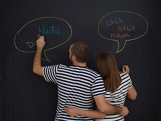 Image showing pregnant couple writing on a black chalkboard