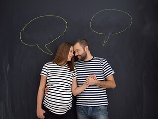 Image showing pregnant couple posing against black chalk drawing board