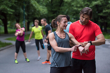 Image showing sporty couple using smart watches