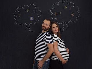 Image showing pregnant couple posing against black chalk drawing board