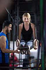 Image showing woman working out with personal trainer on gymnastic rings