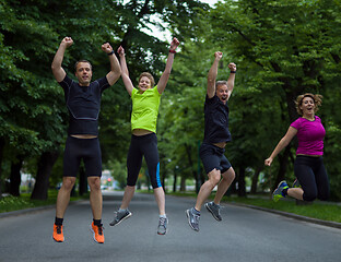 Image showing runners team jumping in the air during  morning training