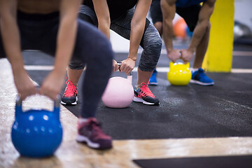 Image showing athletes doing exercises with kettlebells