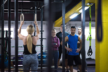 Image showing woman working out with personal trainer on gymnastic rings