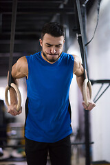 Image showing man working out pull ups with gymnastic rings